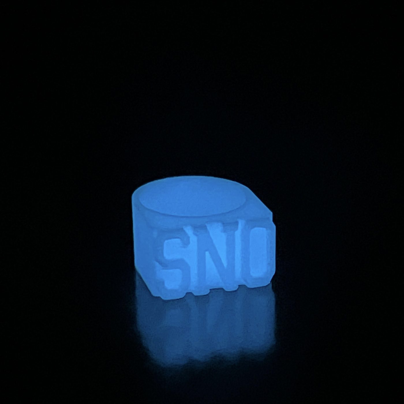The SNO ring glowing frost-blue in the dark